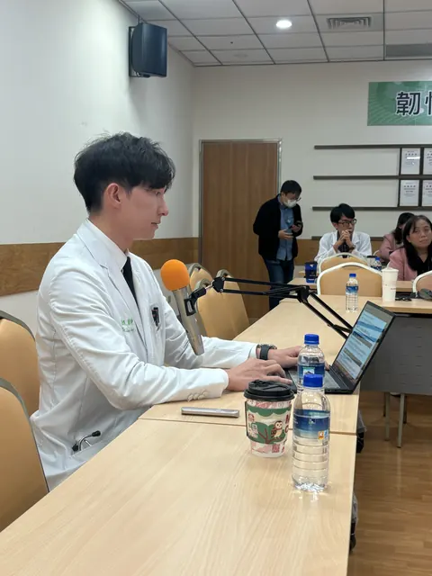 凌濼傑醫師在麥克風前操作筆電準備發表