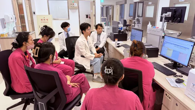 凌濼傑醫師與護理師們圍坐在護理站討論