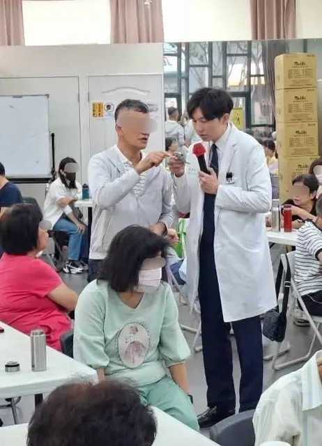 凌濼傑醫師在台下把麥克風遞給聽眾回答問題
