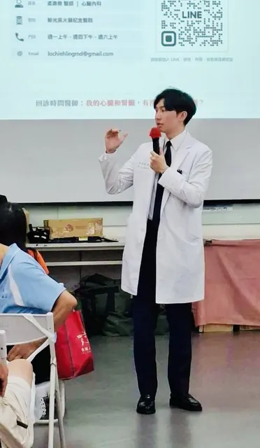 凌濼傑醫師拿麥克風在投影幕前演講